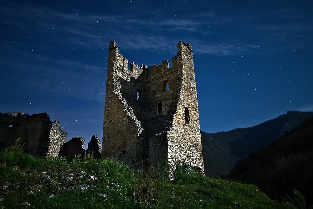 Le château de Miglos sous les étoiles, éclairé par la pleine lune (Arièhe ; photographie : Philippe Contal)