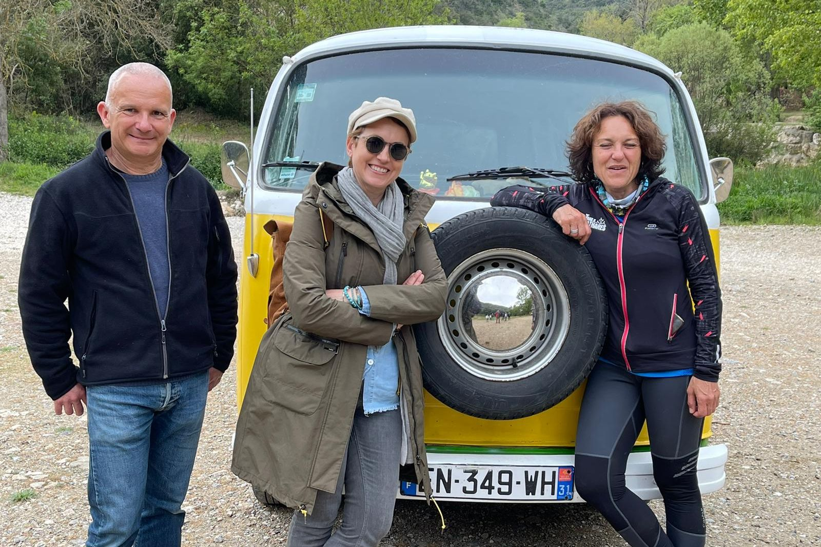 Trois personnes devant un véhicule jaune et blanc, pendant le tournage de Ô la belle vie dans les Corbières.