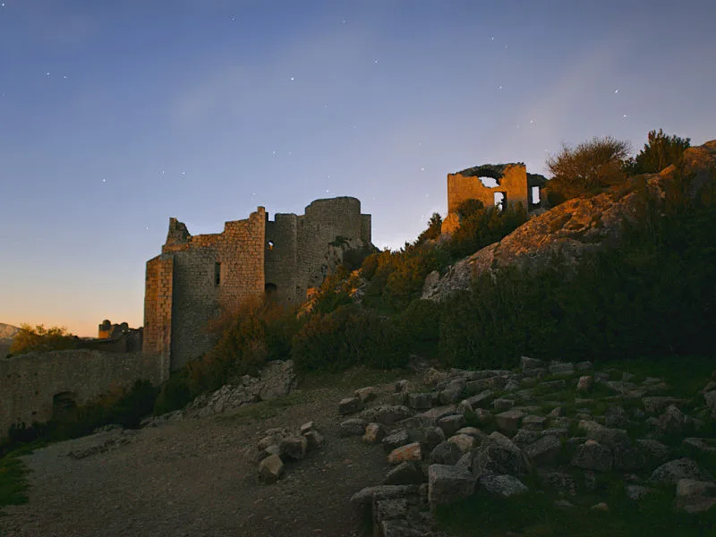 Les derniers rayons du soleil éclairent les murs de Peyrepertuse pendant que les étoiles scintillent dans le ciel (photographie : Philippe Contal, 2016)