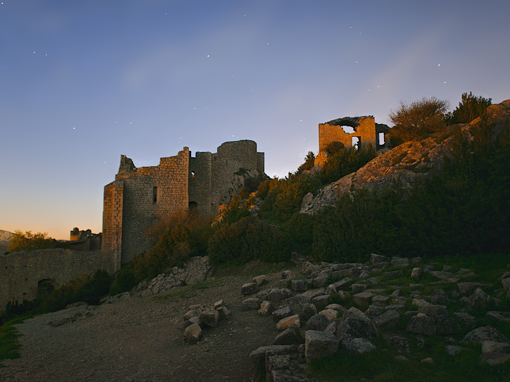 Les derniers rayons du soleil éclairent les murs de Peyrepertuse pendant que les étoiles scintillent dans le ciel (photographie : Philippe Contal, 2016)