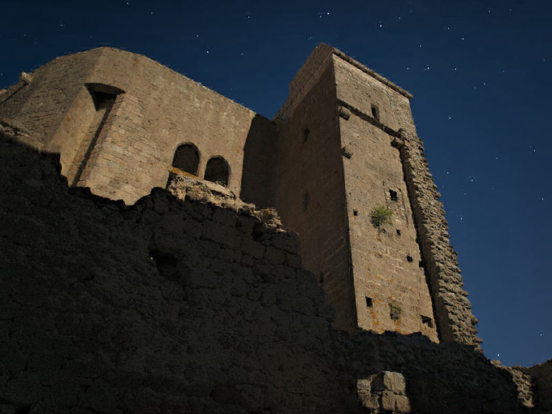 Vue nocturne du donjon cathare de la citadelle de Quéribus avec l'éclairage de la pleine lune (Corbières, Aude ; Photographie : Philippe Contal, 2016)