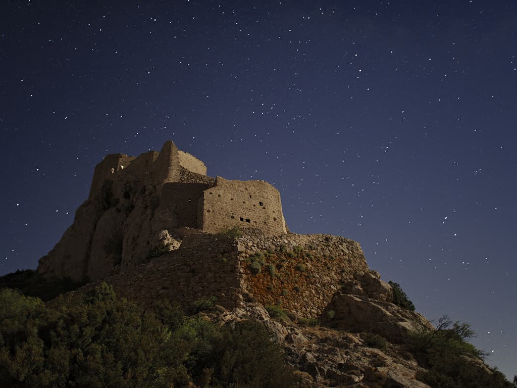 La citadelle de Quéribus en contreplongée nocturne, éclairée par la pleine lune (Corbières, Aude ; photographie : Philippe Contal, 2016)